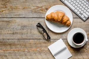 80550814-coffee-and-croissant-for-breakfast-of-businessman-wooden-office-desk-background-top-view-space-for-t