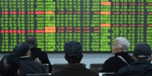 Investors sit in front of a board showing stock information at a brokerage house on the first day of trade in China since the Lunar New Year, in Hangzhou, Zhejiang province, China February 3, 2020. China Daily via REUTERS