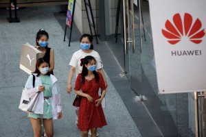 FOTO DE ARCHIVO: Mujeres con mascarillas durante la epidemia de coronavirus ante una tienda de Huawei en un complejo comercial de Pekín, China, 14 de julio de 2020. REUTERS/Tingshu Wang