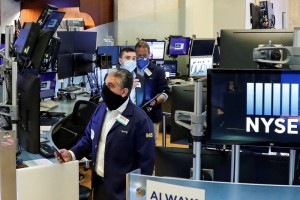 FILE PHOTO: Traders wearing masks work, on the first day of in-person trading since the closure during the outbreak of the coronavirus disease (COVID-19) on the floor at the New York Stock Exchange (NYSE) in New York, U.S., May 26, 2020. REUTERS/Brendan McDermid